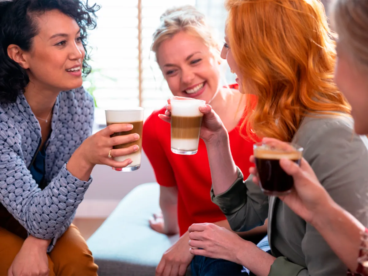 Women talking while drinking different beverages.