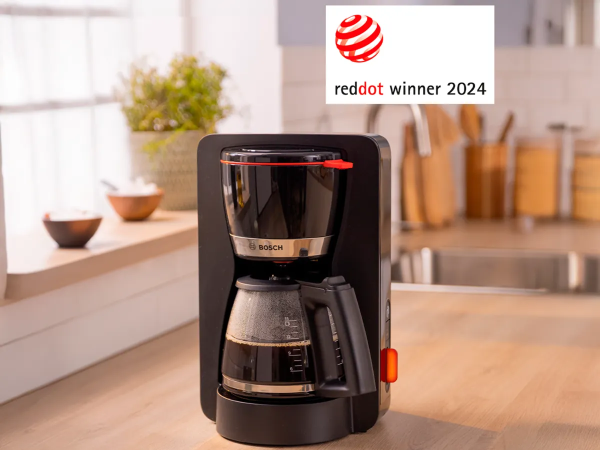 Máquina de café MyMoment preta em cima da bancada da cozinha.