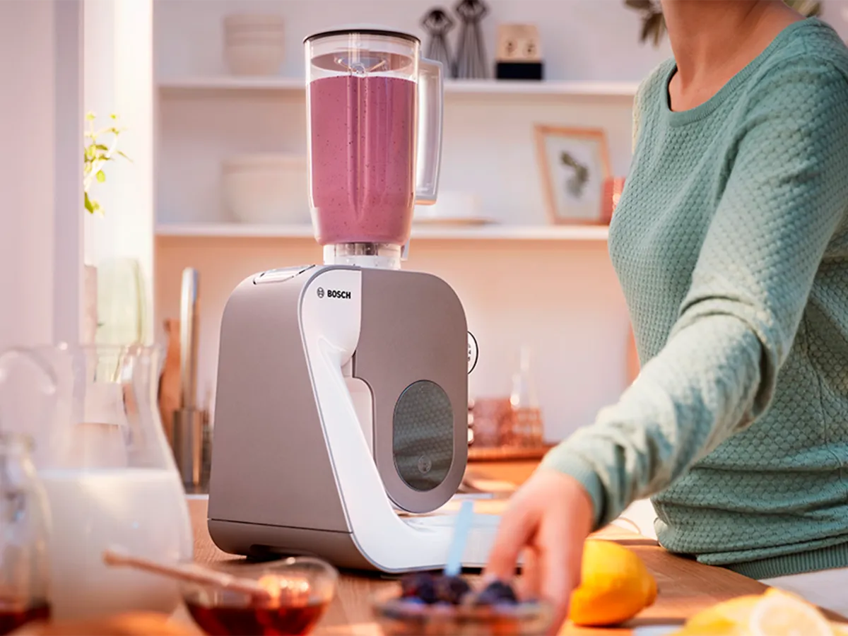 Uma pessoa usa o acessório de liquidificador da batedeira de pé para fazer um smoothie.