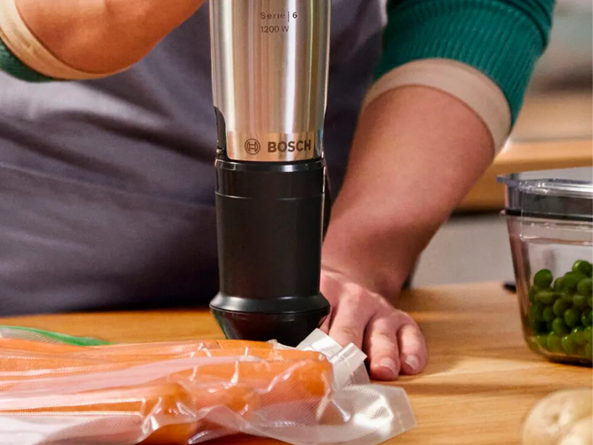 Uma pessoa utiliza a função de selagem a vácuo para remover o ar de um saco plástico com alimentos.