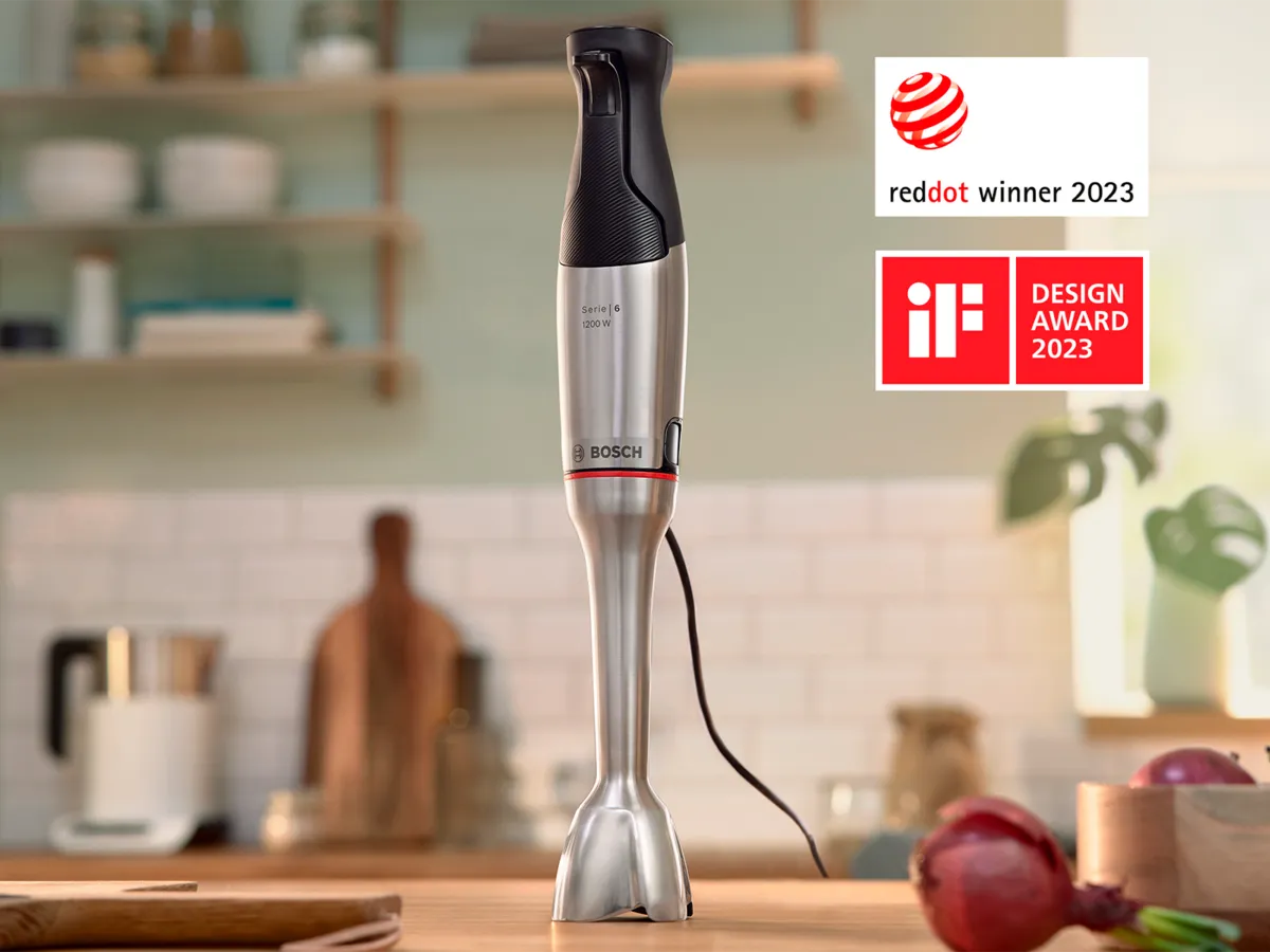 Liquidificador de mão Bosch vencedor do Red Dot e frutas cortadas sobre uma bancada da cozinha.