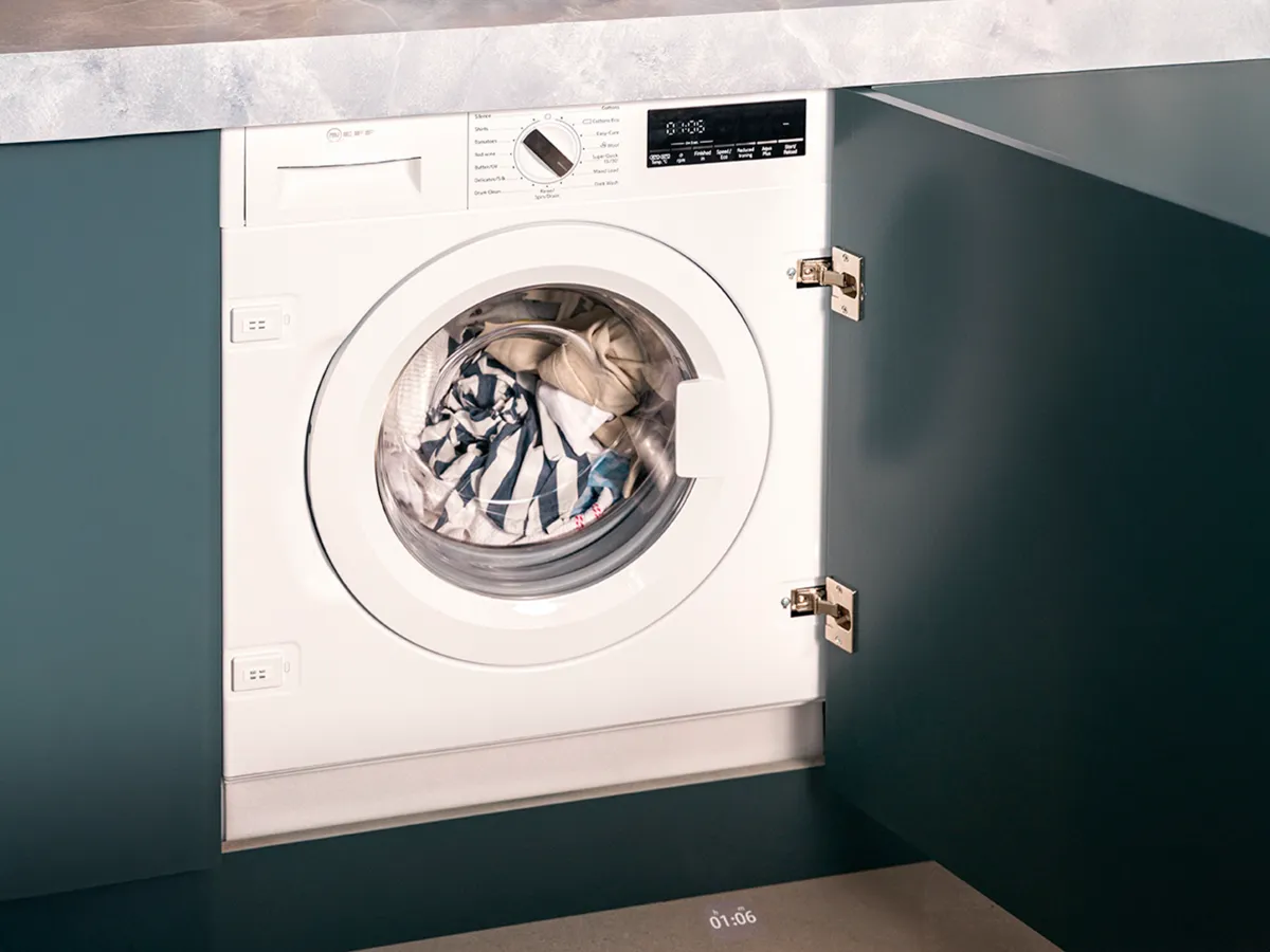 Blick von oben auf Waschmaschine im Schrank unter der Küchenarbeitsplatte.