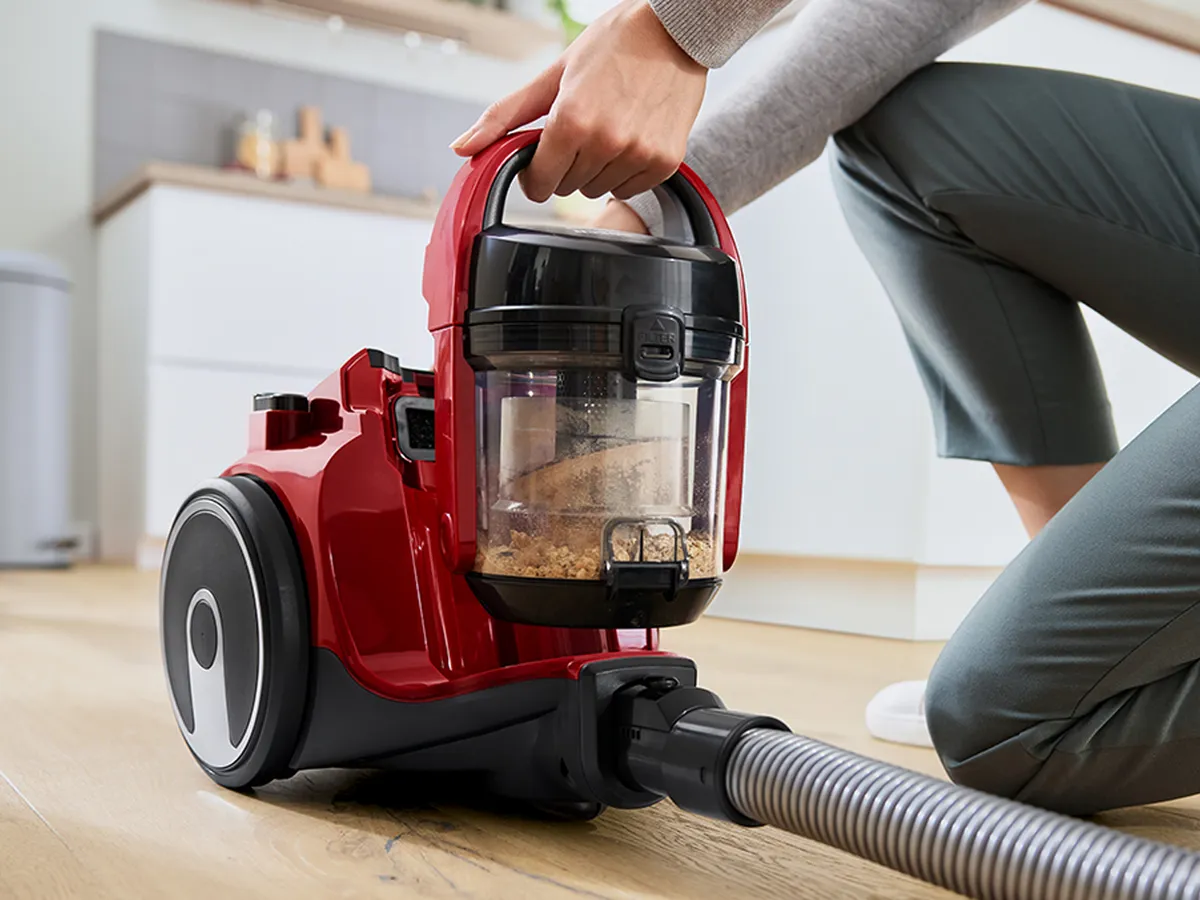 Bosch sesalnik brez vrečke prikazan z enostavno praznjenjem posode za prah.