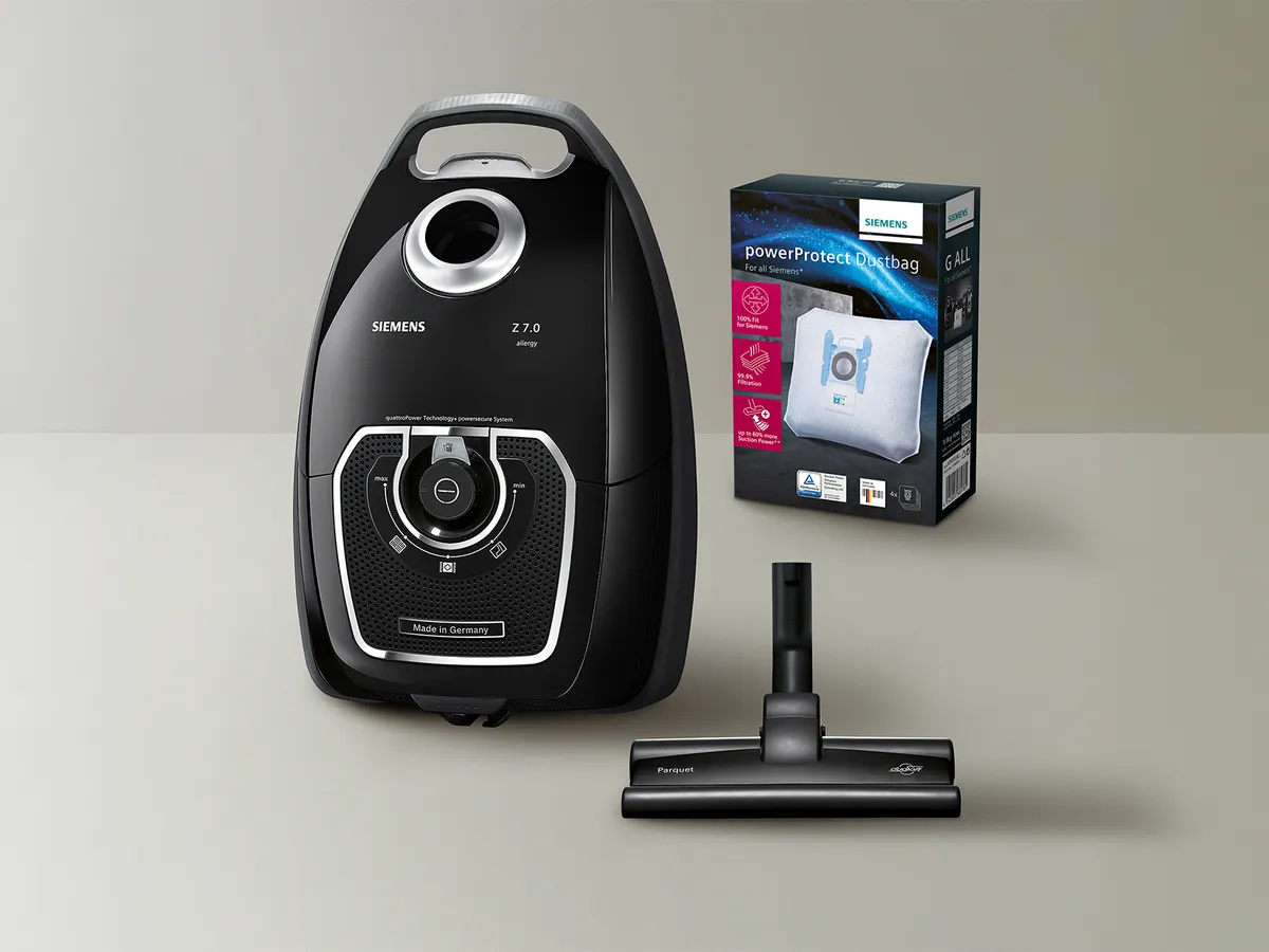 Un aspirateur Siemens avec des accessoires et une boîte de sacs à poussière.