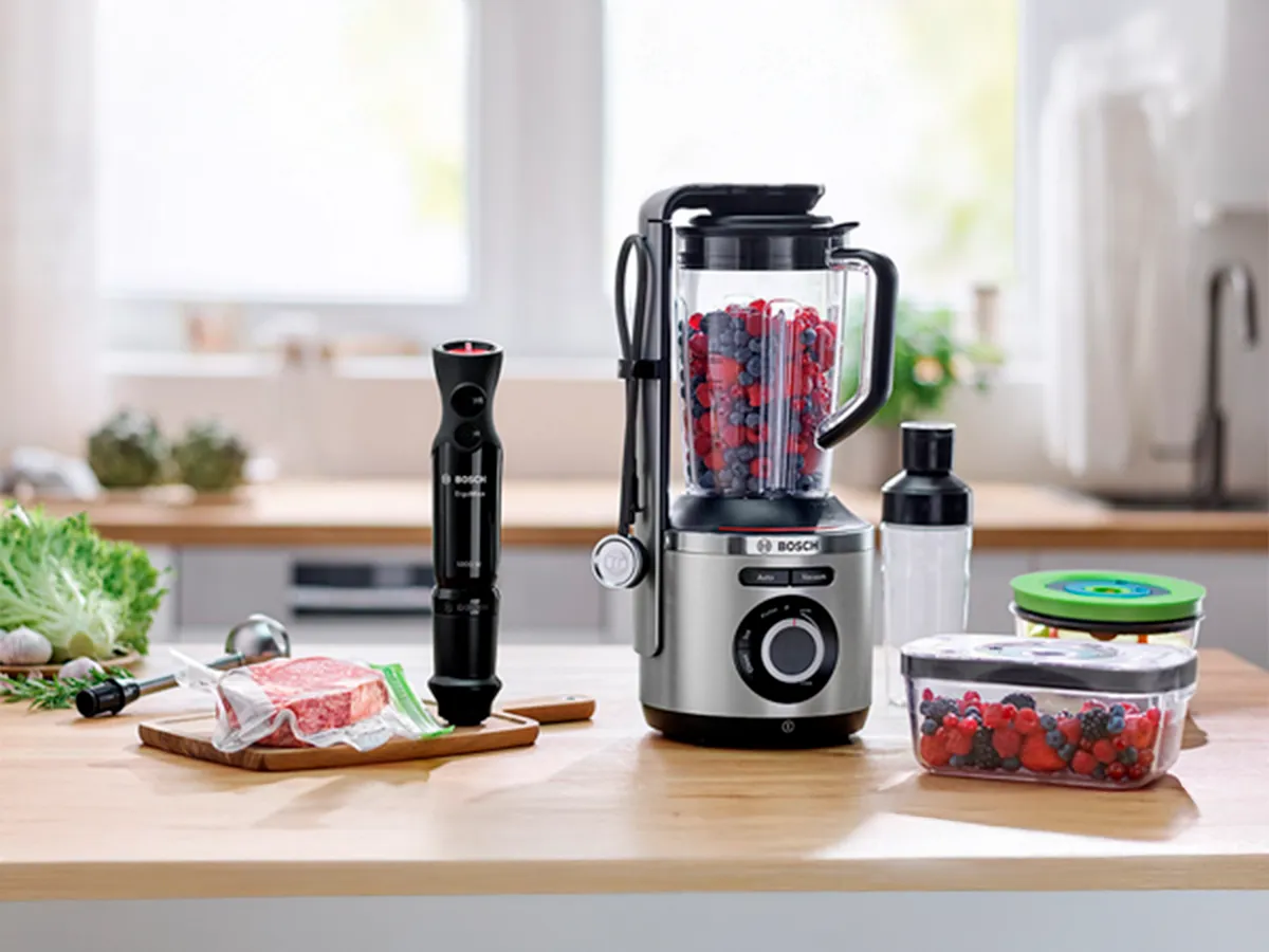 Varinha e liquidificador Bosch com selagem a vácuo numa bancada de cozinha ao lado de recipientes compatíveis.