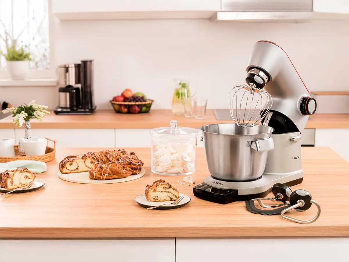 Contador de cozinha com produtos assados, misturador e produtos frescos. 