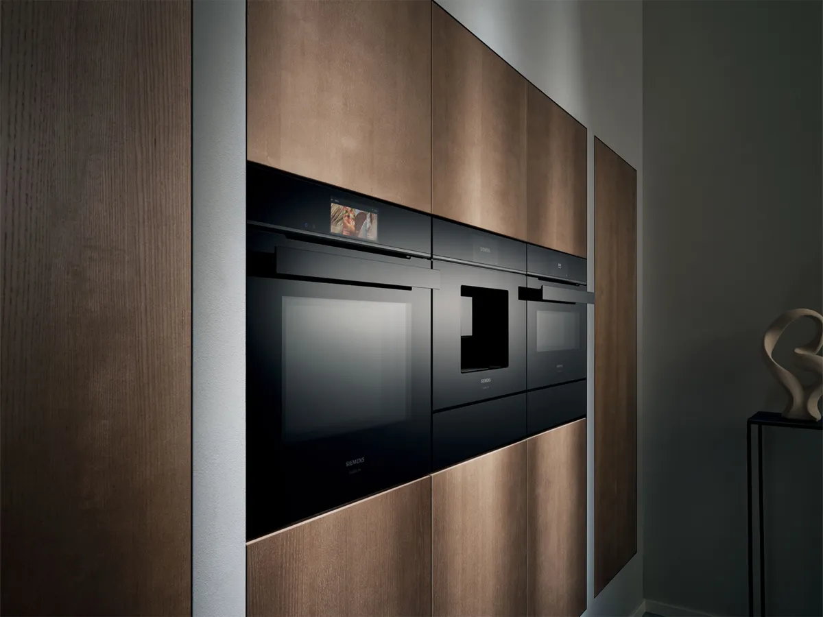 Indbyggede køkkenapparater fra Siemens sømløst integreret i moderne træfronter.