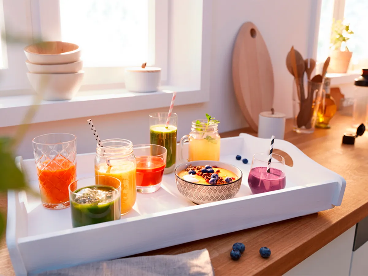 Diferentes smoothies em pé sobre uma bancada na cozinha.