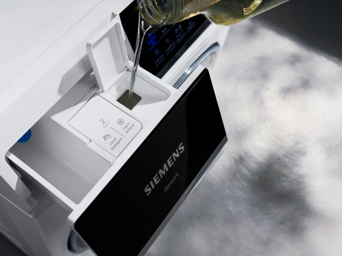 Pouring detergent into a Siemens washing machine dispenser drawer.