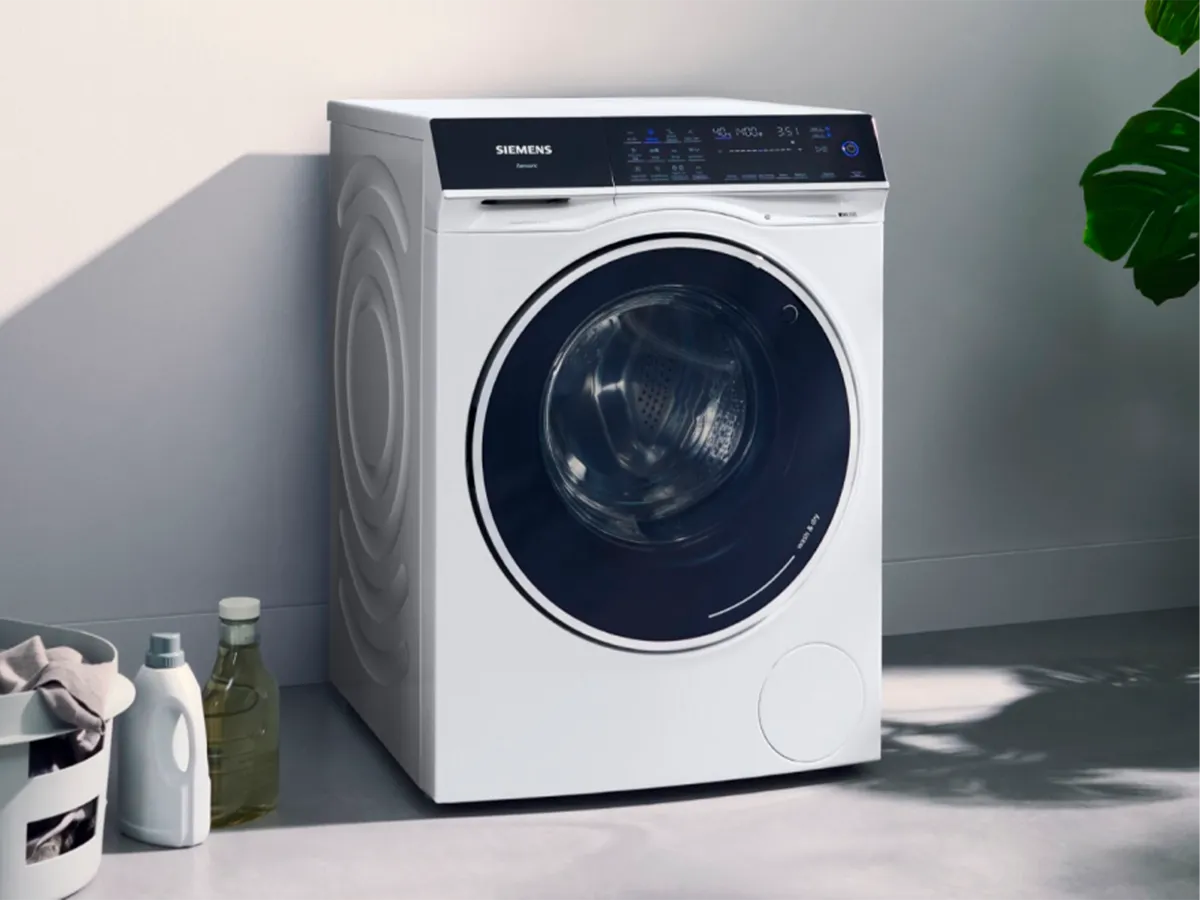 Siemensin kuivaava pesukone modernilla muotoilulla minimalistisessa kodinhoitohuoneessa.