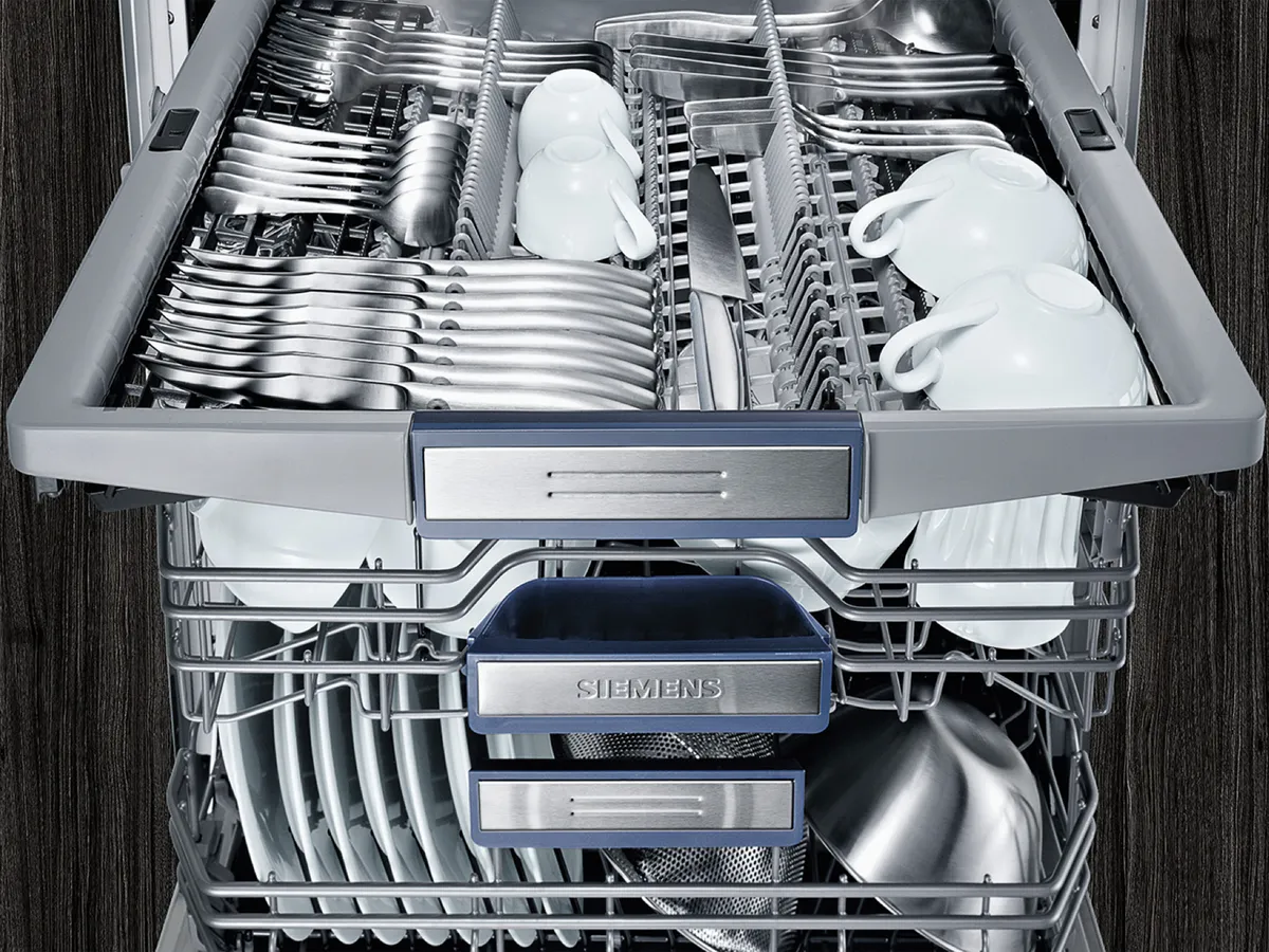 Open dishwasher with clean dishes and visible Siemens logo.