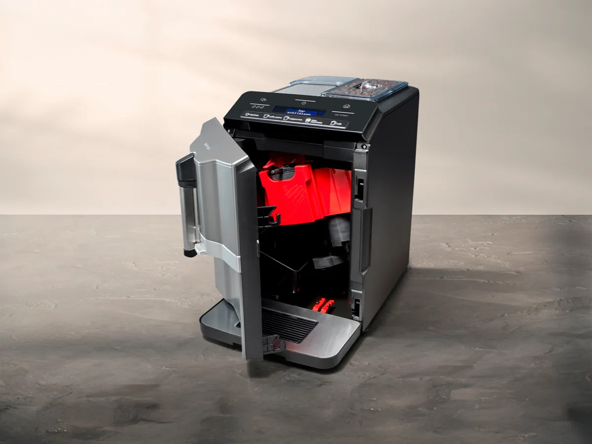 La porte avant de la machine à espresso entièrement automatique EQ300 est ouverte, l'intérieur et l'unité de préparation sont visibles.