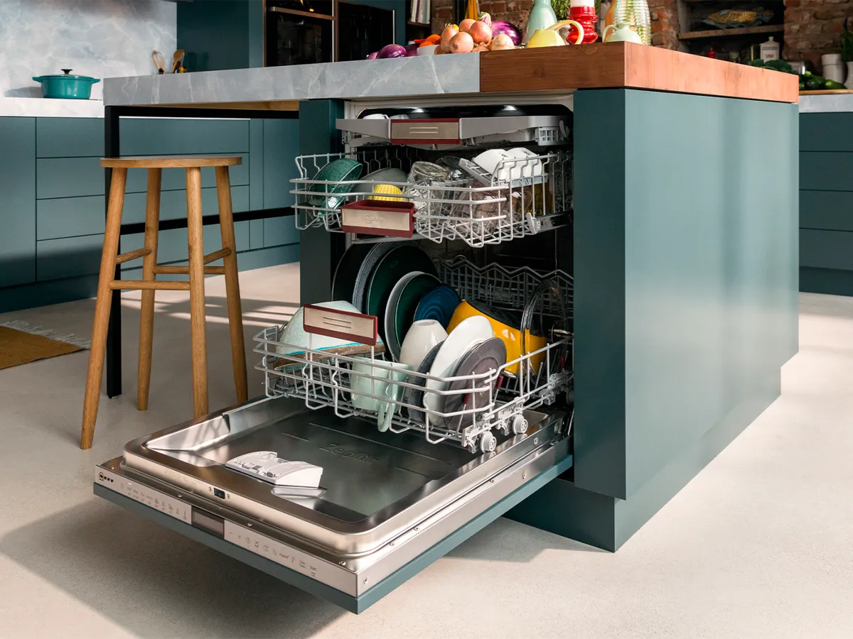 A fully-integrated 60 cm dishwasher with an open door to show three filled baskets