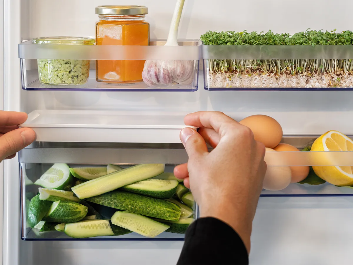 A closer view of a fridge door on which Flex Cooling storage boxes are mounted with fresh condiments and ingredients in them.