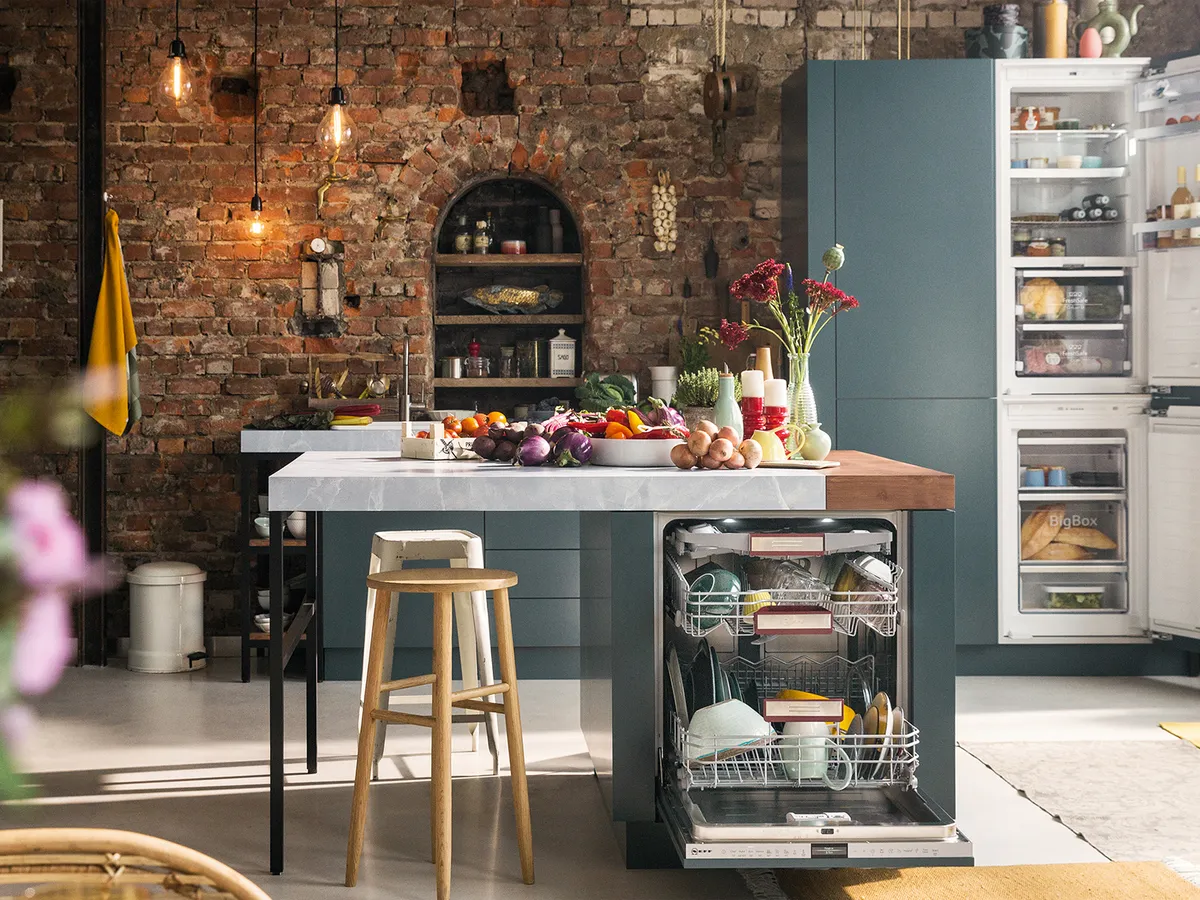 An open built-in fridge freezer in an industrial-style kitchen.