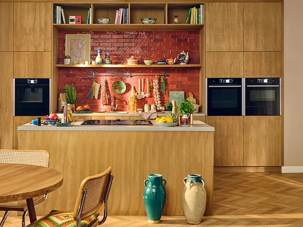 Wide shot of warm wooden kitchen with red tiles