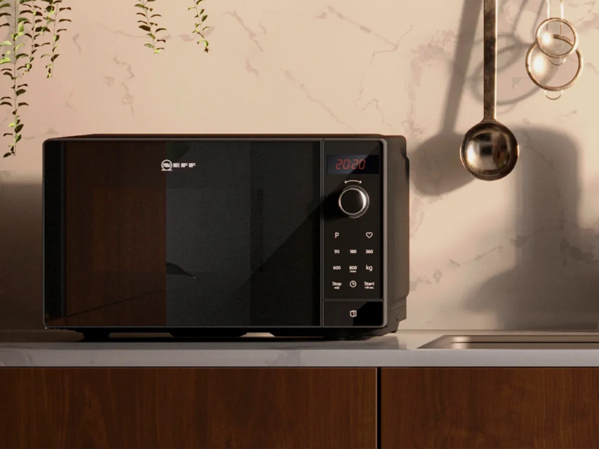 Eine freistehende NEFF-Mikrowelle auf einer weißen Arbeitsplatte in der Nähe des Waschbeckens.