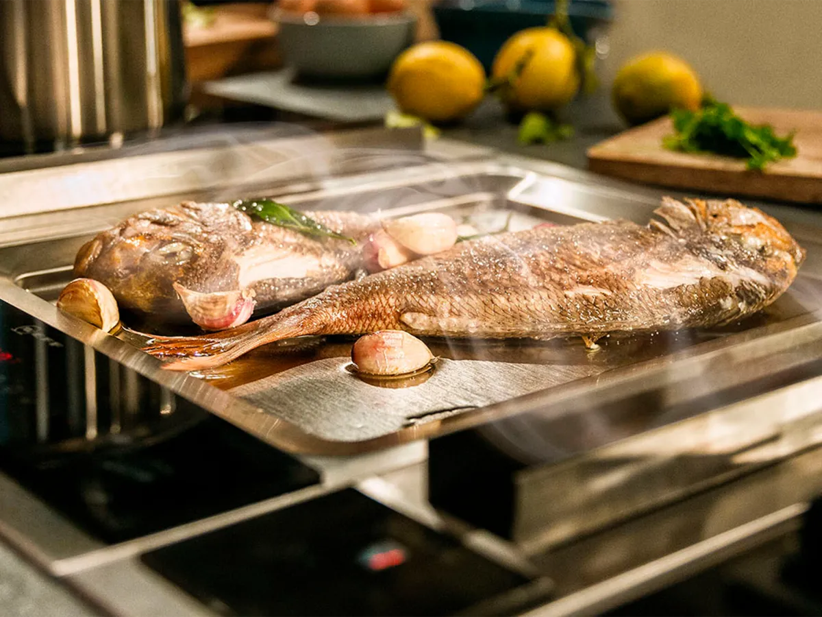 Риба се пържи, парата се изсмуква от вградената вентилация.