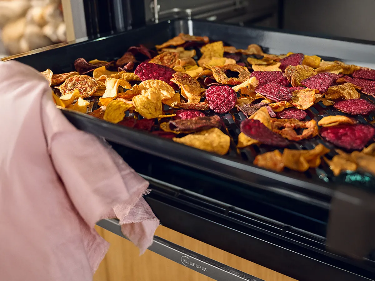 Open oven with tray of colourful airfried vegetables  