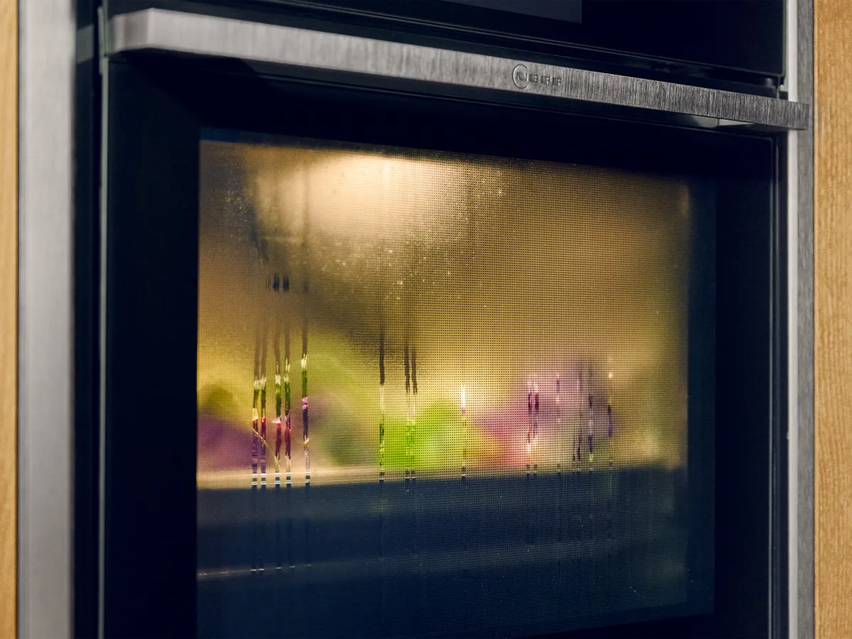 Close-up of N90 Metallic Silver oven showing Intensive Steam behind the steamed up oven door  