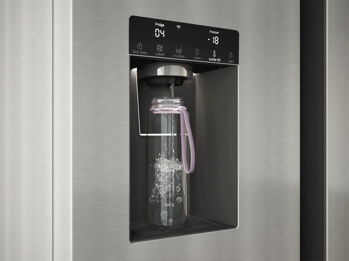 O dispensador de gelo de um frigorífico moderno enche um copo transparente com gelo em cubos.