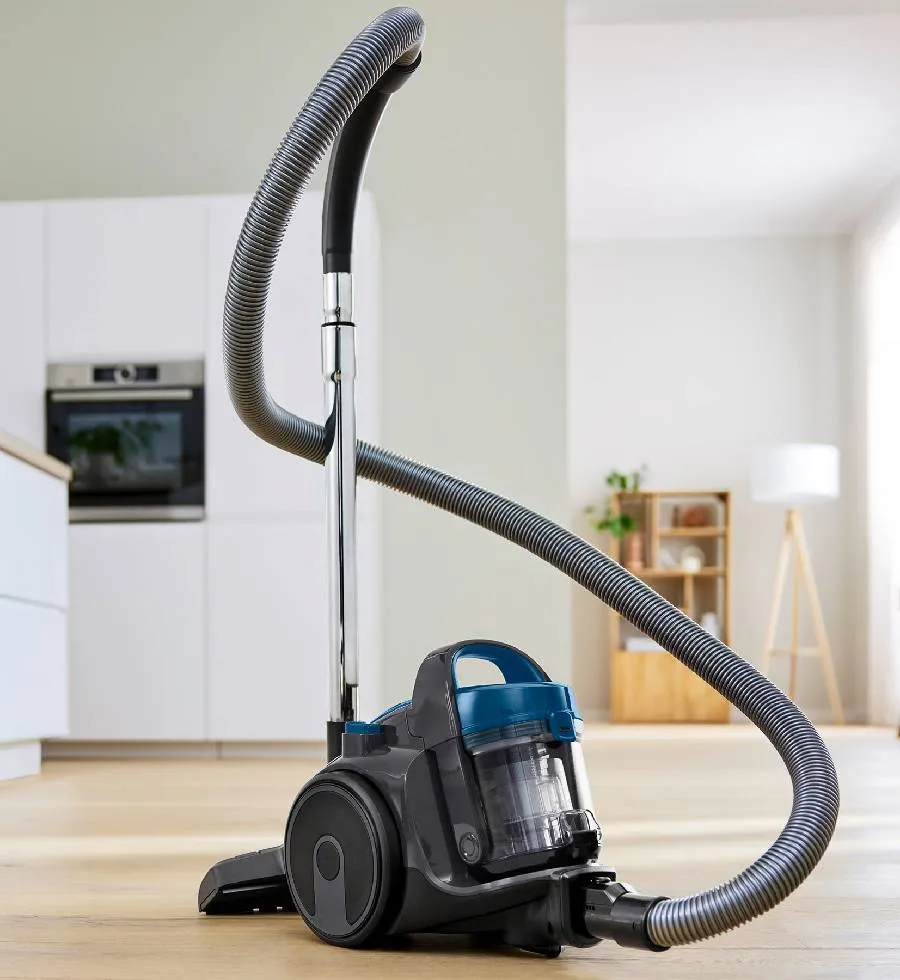 Una donna sale le scale con un modello a cilindro senza sacchetto.