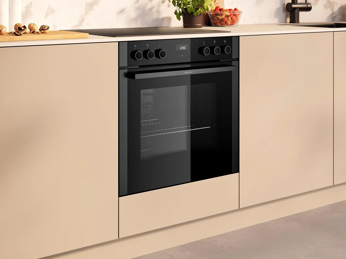 Eine elegante moderne Küche mit einem eingebauten schwarzen Backofen und cremefarbenen Schränken, der über Regler und ein digitales Display an der Front des Ofens verfügt, um den Ofen und das Kochfeld darüber zu steuern.