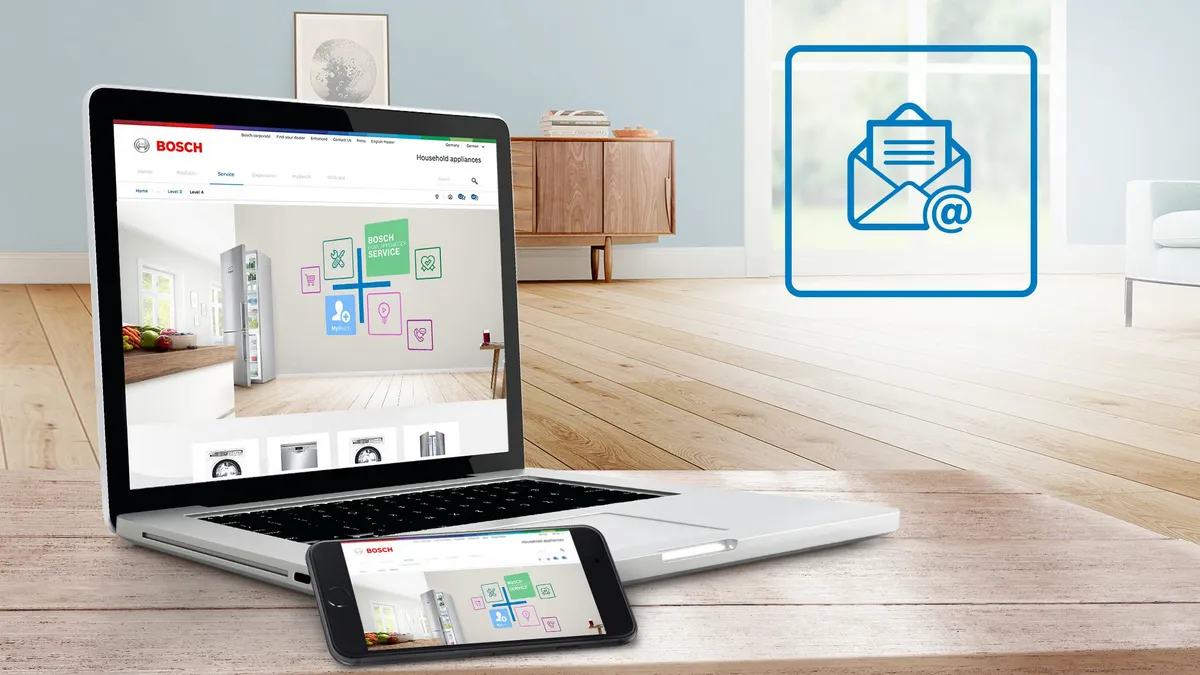 Laptop i smartfon z stroną Bosch w jasnym, nowoczesnym wnętrzu.