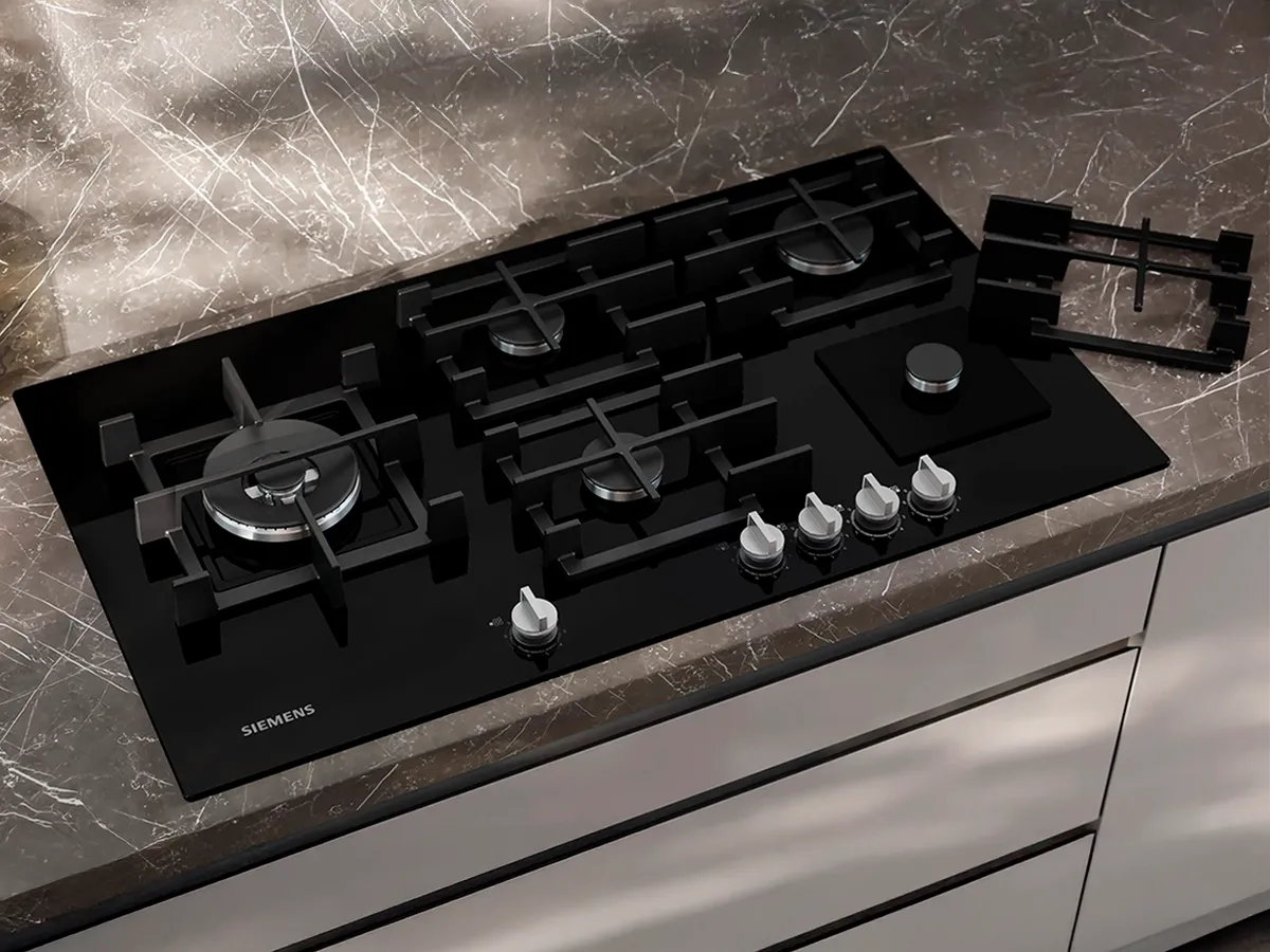 Top-down view of a Siemens gas hob in a grey marble kitchen countertop.