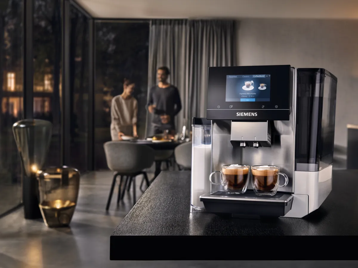 En moderne Siemens kaffemaskine, der forbereder to kopper kaffe i et strømlinet køkken.