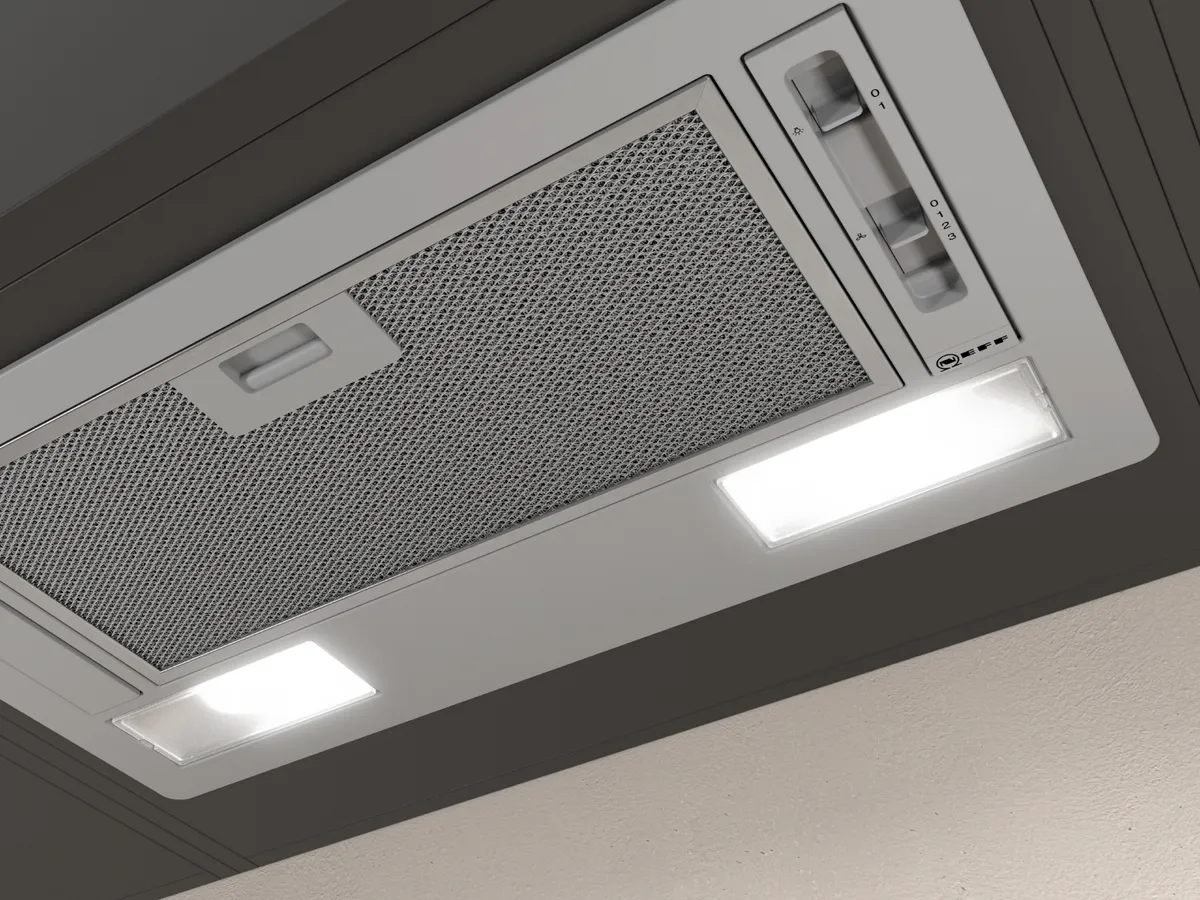 An der Decke montierte Dunstabzugshaube mit Metallfilter und zwei LED-Leuchten für bessere Beleuchtung und Belüftung.