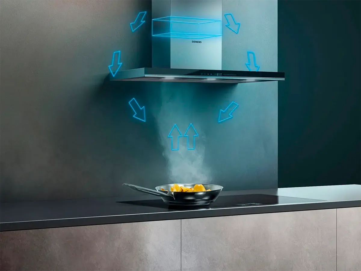 Uma chaminé de cozinha moderna acima de uma frigideira com alimentos, apresentando setas indicando o fluxo de ar ao redor da área de cozimento para remover fumaça e odores.