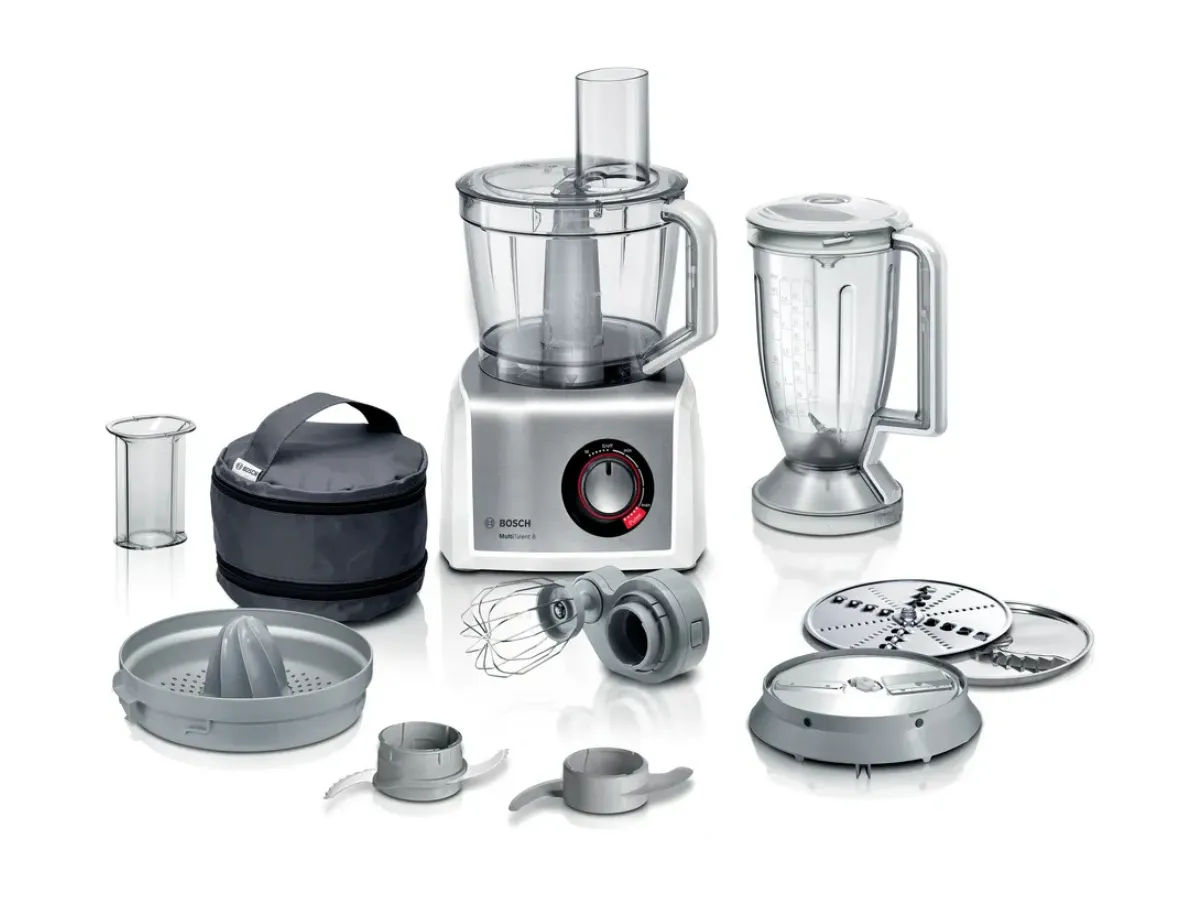 A Bosch food processor kit displayed neatly on a black background, including a food processor with a clear bowl, a blender, a variety of attachments such as a juicer, whisks, a blender jug, and other accessories for versatile food preparation.
