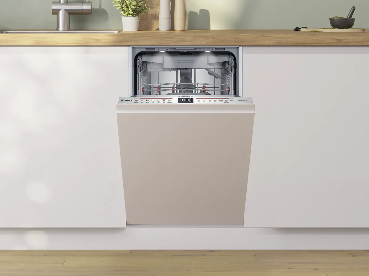 An open Bosch dishwasher in a modern kitchen, showcasing its interior racks and control panel.