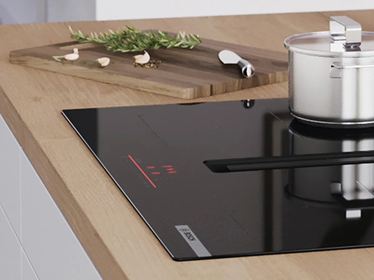 Uma cozinha com um elegante fogão de indução preto, uma panela de aço inoxidável e uma tábua de cortar de madeira.