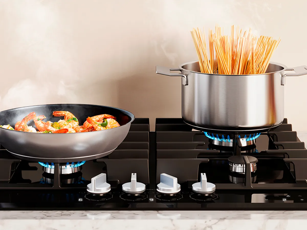 Um fogão com uma frigideira de legumes salteados e uma panela de espaguete a ferver, com vapor subindo de ambos.