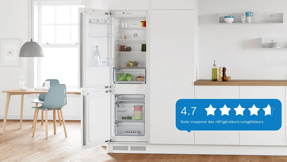 Une cuisine avec un réfrigérateur Bosch blanc, partiellement ouvert, affichant une note de 4,7 étoiles sur le côté.