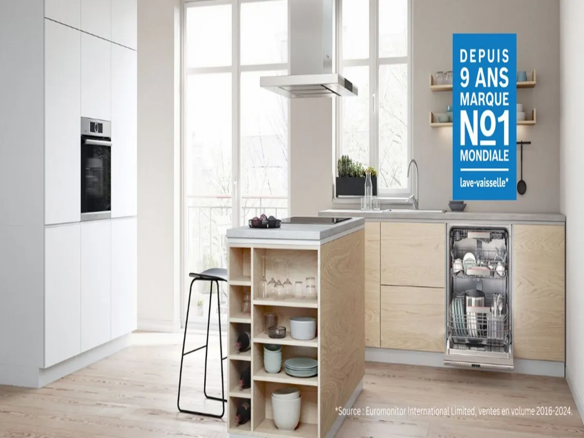 Cuisine moderne avec des armoires élégantes, un agencement ouvert et un lave-vaisselle visible. Un panneau indique « Marque n°1 dans le monde depuis 9 ans ».