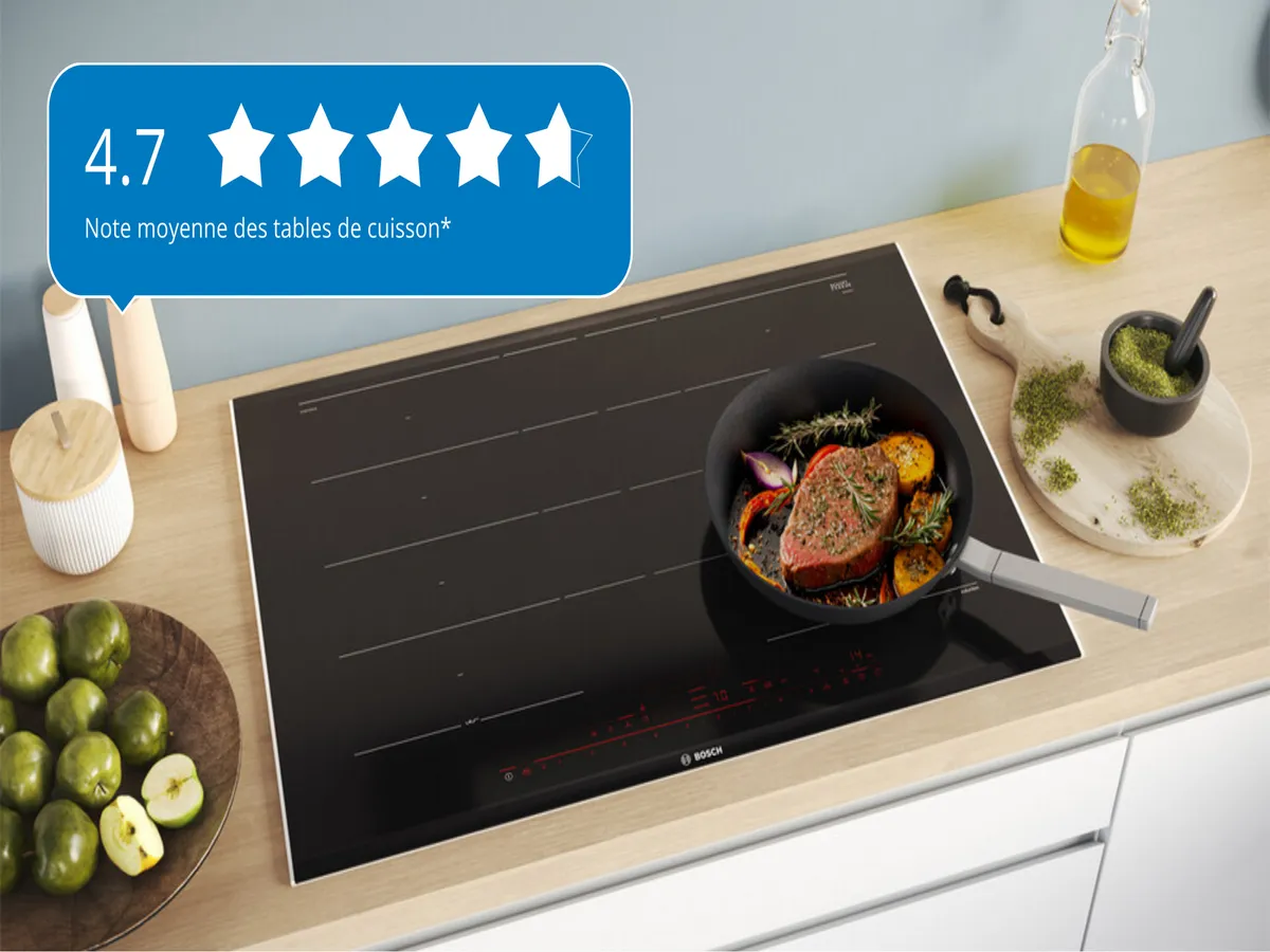 Une table de cuisson à induction Bosch avec une poêle de légumes et un steak, notés 4,7 étoiles, entourés d'ingrédients.