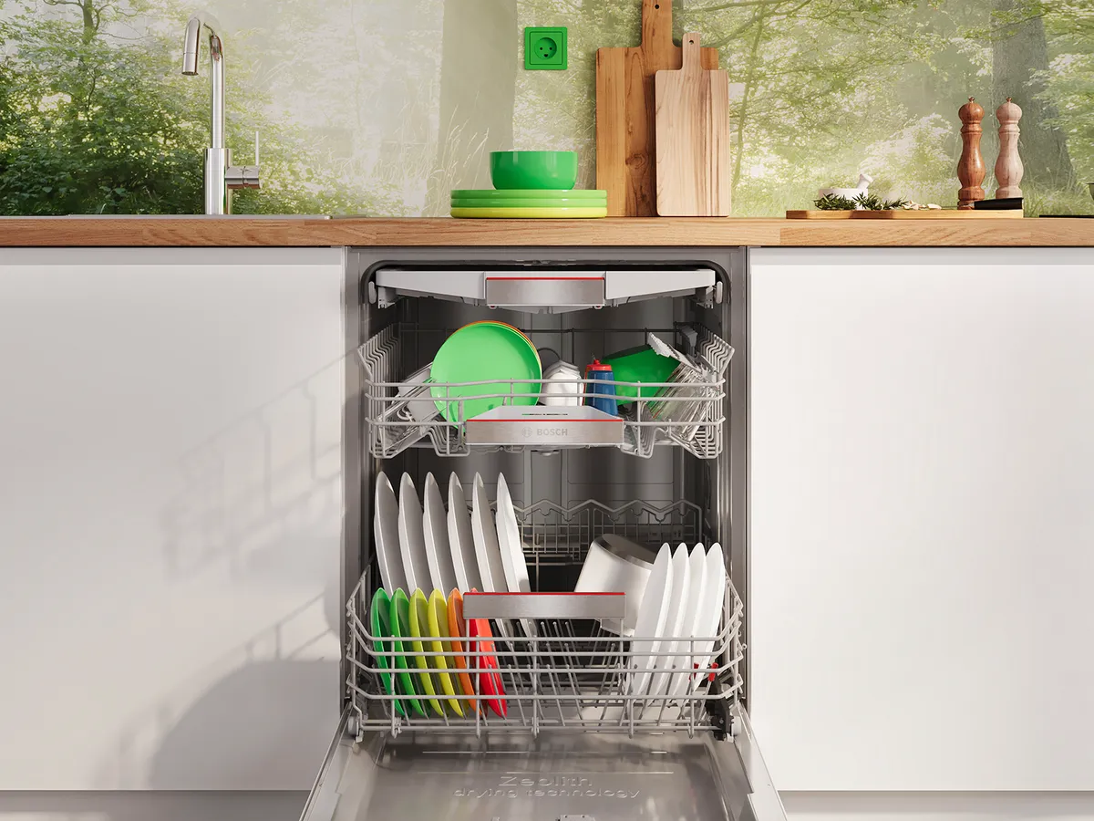Open Bosch dishwasher in a bright kitchen, loaded with dishes and bowls.