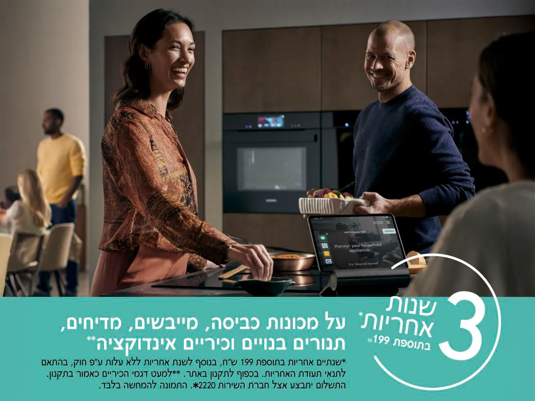 אדם המשתמש בטאבלט עומד ליד מטבח מודרני, מציג אפשרויות לניהול מכשירי חשמל ביתיים עם ארוחה ביד.