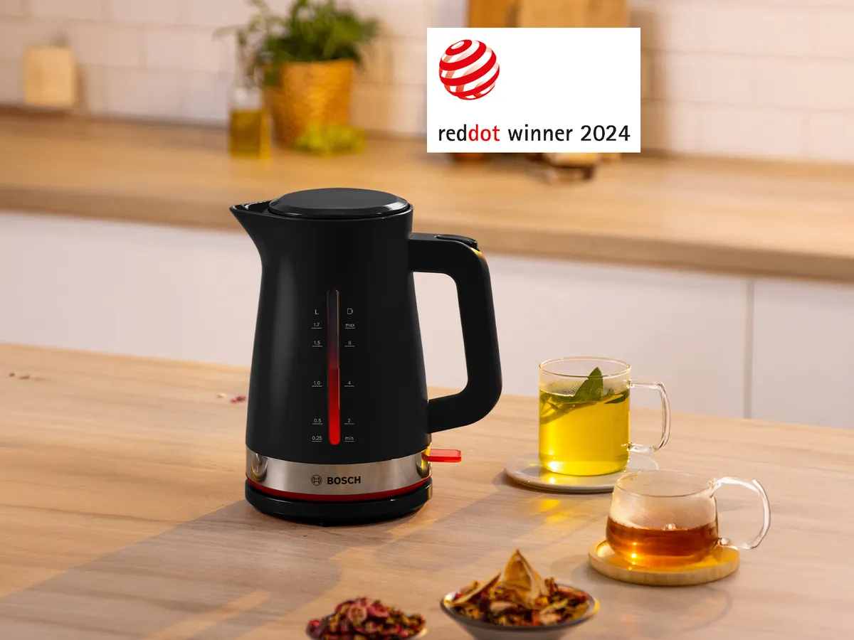 Ένας βραστήρας MyMoment και γύρω του ζεστά ροφήματα πάνω σε έναν πάγκο κουζίνας.