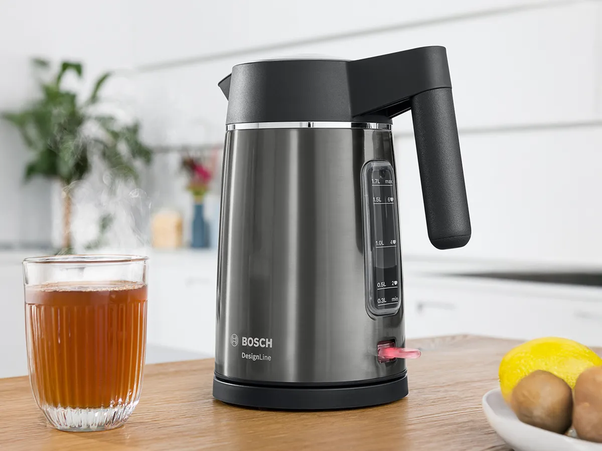 Ένας βραστήρας DesignLine πάνω σε έναν πάγκο κουζίνας, δίπλα σε ένα ζεστό τσάι σε ποτήρι και είδη πρωινού.