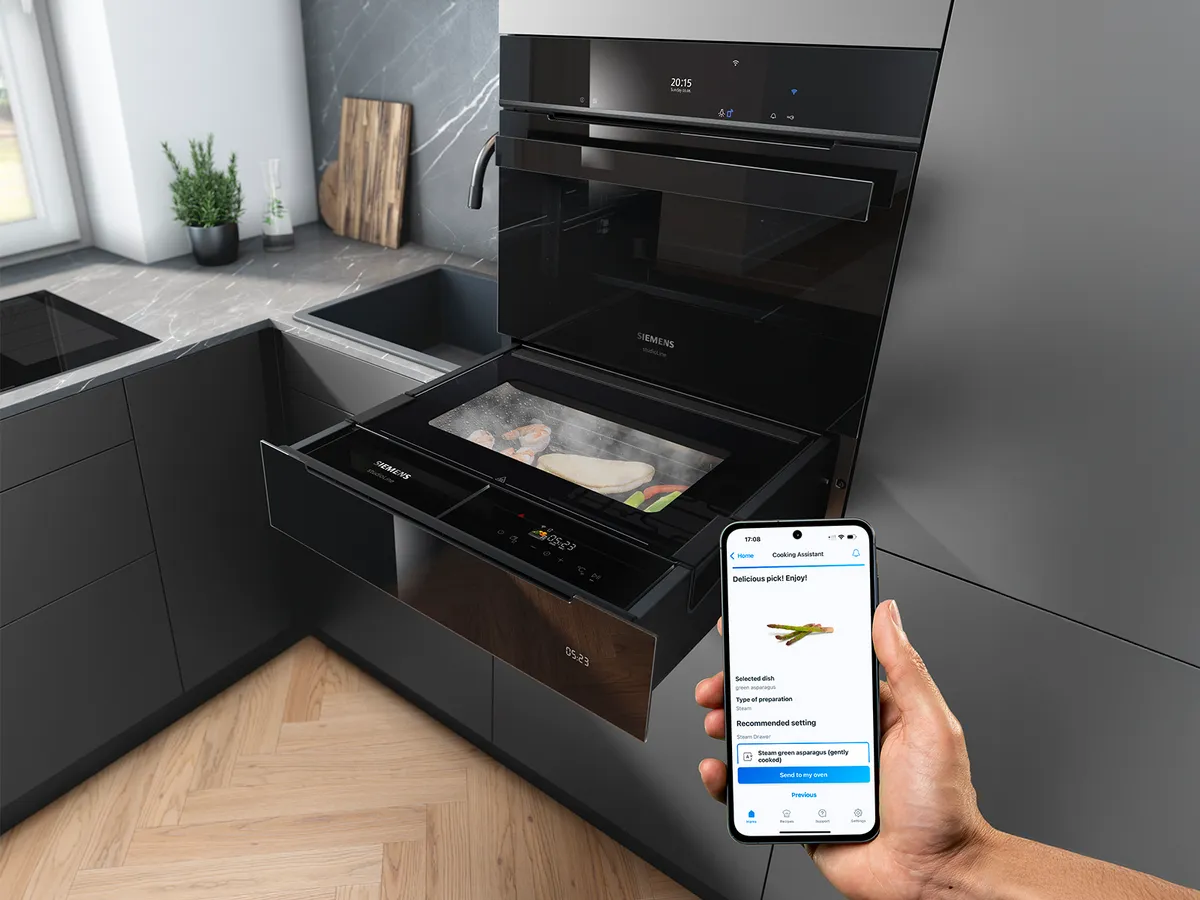 Smarte Dampfschublade von Siemens. Im Vordergrund ist ein Smartphone mit Home Connect App zu sehen.