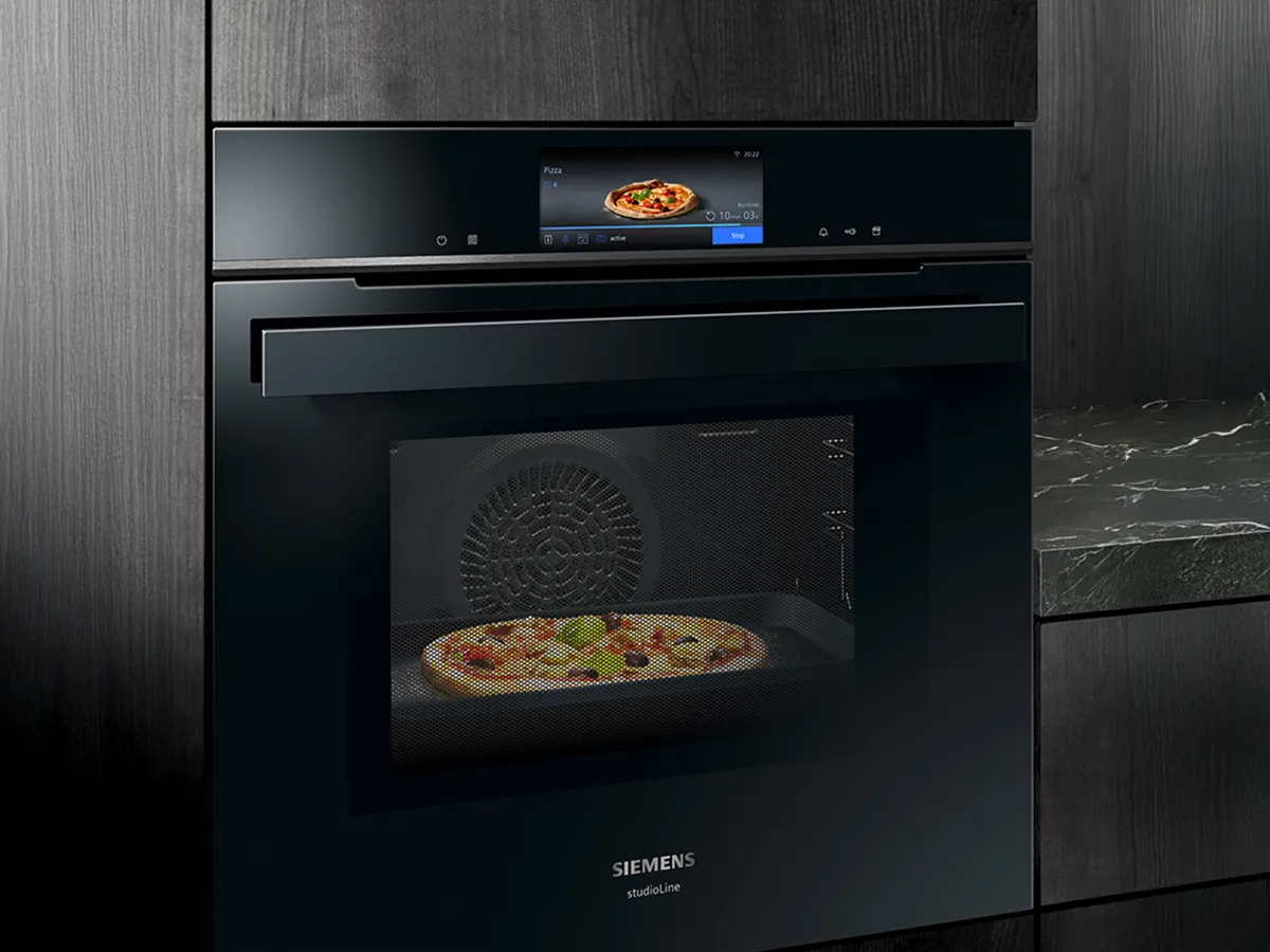 En sort Siemens ovn med digitalt display bager en pizza