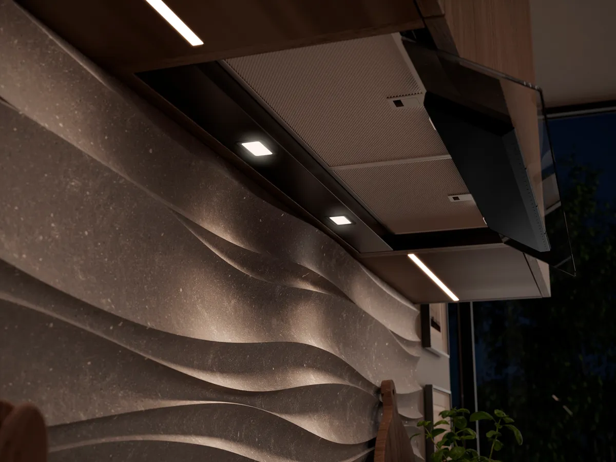 Cappa da cucina sotto mobili con illuminazione integrata, installata sopra uno schienale texturizzato.