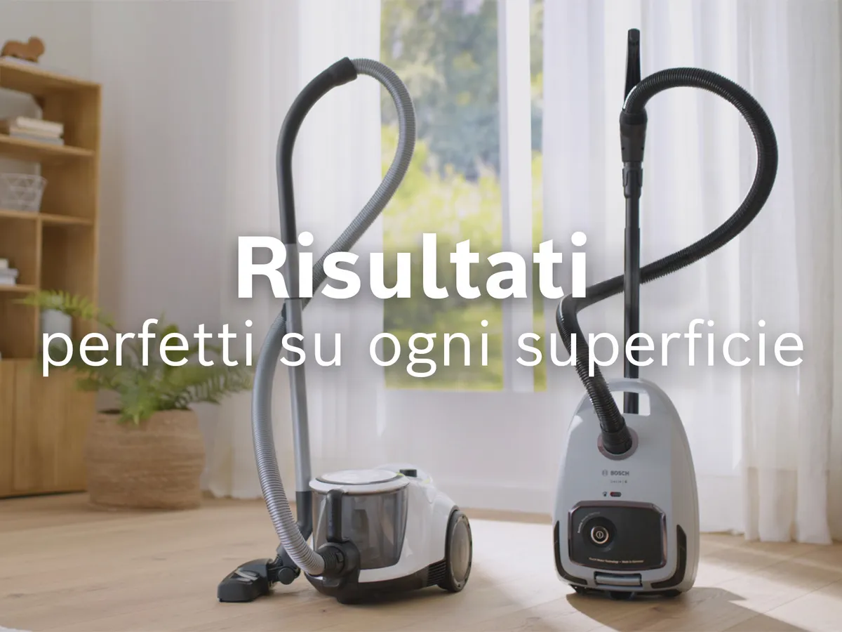 Due aspirapolvere con sacco di Bosch si trovano davanti alla finestra di uno studio con la scritta “performance for all surfaces” sovrapposta.