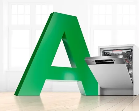 Ein großer grüner Buchstabe A; steht neben einer offenen Geschirrspülmaschine in einem hellen, modernen Raum mit Holzboden