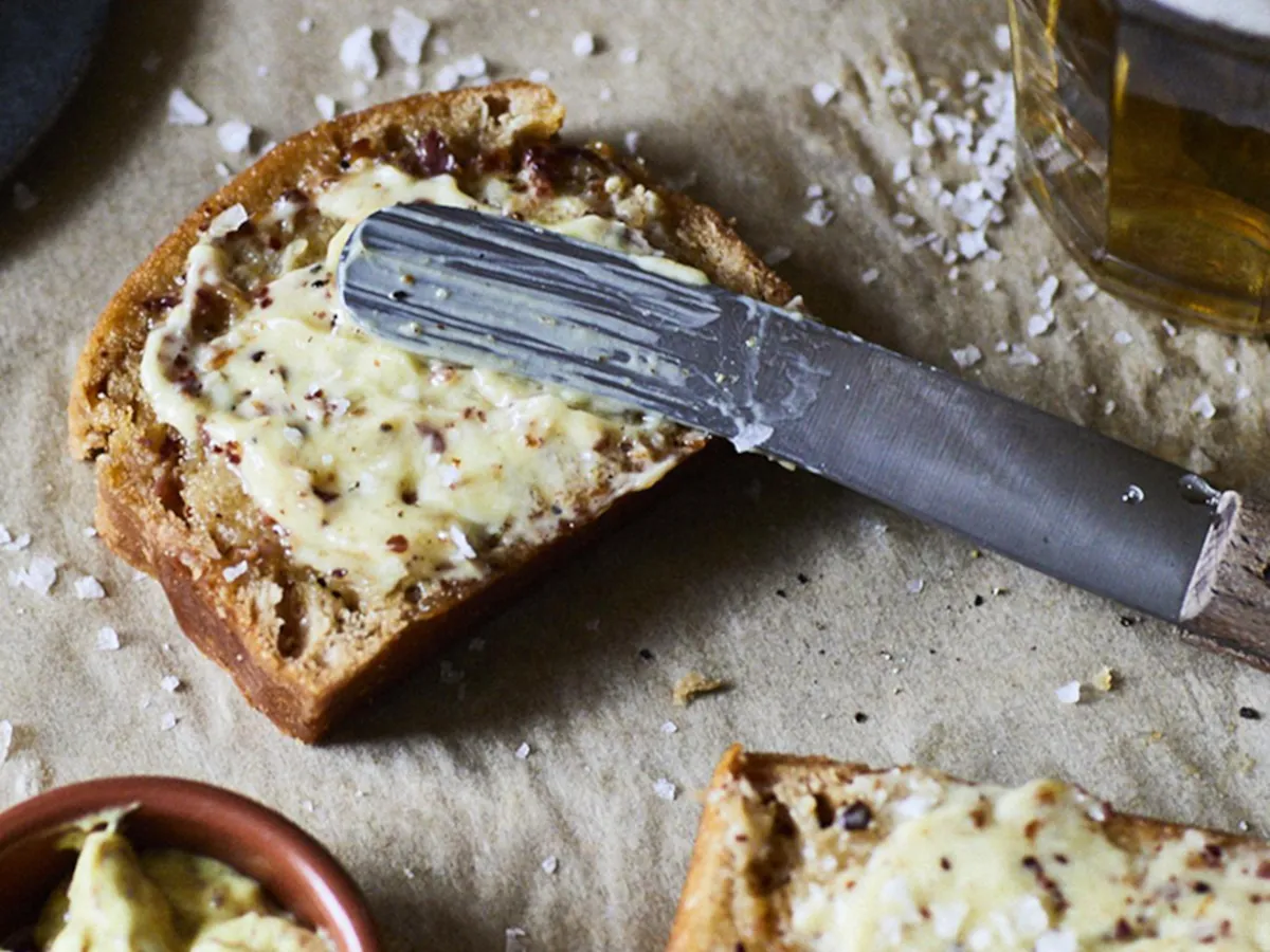 Tablescape with linen tablecloth, wine glasses and earthen caksestands and orange glass vases.