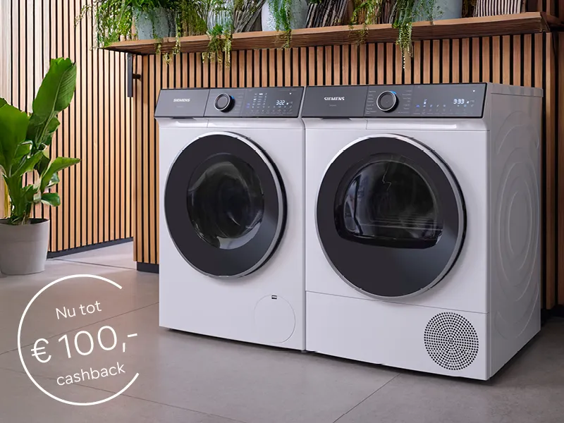 Siemens wasmachine en droger set in wasruimte met houten lattenwerk en groene planten, met "Actie afgelopen" melding in cirkel